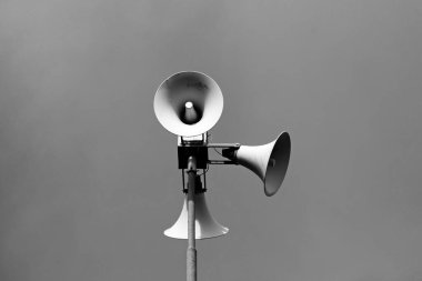 Yerin üstünde bir direkte oturan üç megafon. 