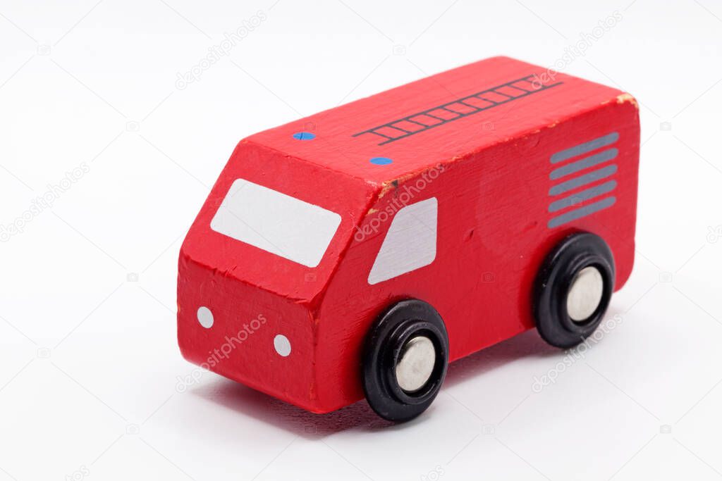 a red toy car in wood on white background 