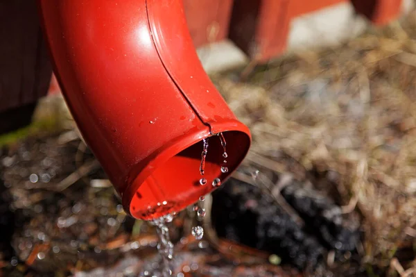 Water Dat Het Voorjaar Uit Een Rode Regenpijp Stroomt — Stockfoto