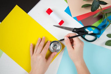 Renkli kağıt, makas, yapıştırıcı, beyaz masa üzerindeki kalem. Anneler Günü için çocuk el işi. Adım adım talimat veriyorum. Adım 2.