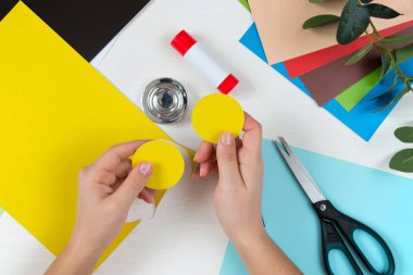 Renkli kağıt, makas, yapıştırıcı, beyaz masa üzerindeki kalem. Anneler Günü için çocuk el işi. Adım adım talimat veriyorum. Adım 3.