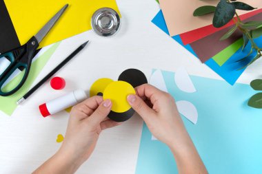 Renkli kağıt, makas, yapıştırıcı, beyaz masa üzerindeki kalem. Anneler Günü için çocuk el işi. Adım adım talimat veriyorum. Altıncı adım.