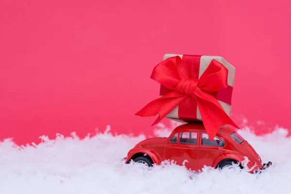 红色复古车 雪地和粉色背景的礼物 新年贺卡的简约风格 — 图库照片