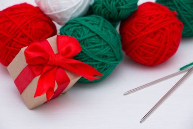 Kırmızı ve yeşil iplik derileri ve beyaz arka planda bir hediye kutusu. Noel konsepti.