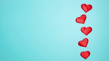 Red hearts on a blue background. Valentine's day concept. Stop motion animation.