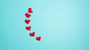 Red hearts on a blue background. Valentine's day concept. Stop motion animation.