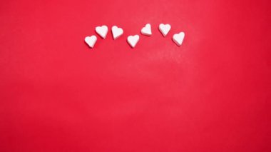 Heart made of sweet marshmallows on a red background. Valentine's day concept.