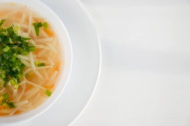 Hafif arka planda bir tabak tavuk çorbası. Ev yapımı sağlıklı yiyecek konsepti.