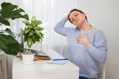 Siyah saçlı mutlu kız evde dizüstü bilgisayarla çalışıyor. Uzaklık eğitimi ve çalışma.