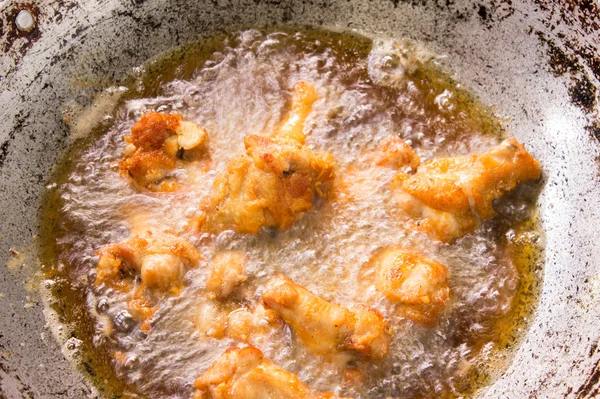 Chicken drumstick in boiling oil iron pan — Stock Photo, Image