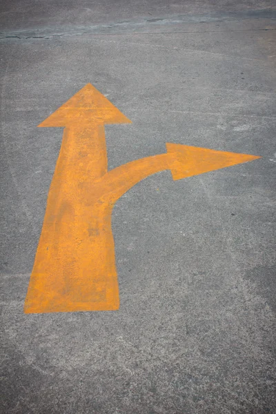 Żółty ruchu strzałka oznakowania na drodze — Zdjęcie stockowe
