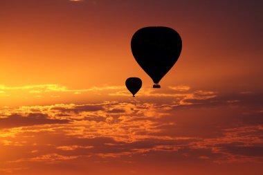 Kızıl bir gökyüzü altında balon turu