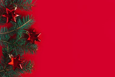 Noel arkaplanı ladin dalları ve kırmızı süslemelerle dolu. Düz yatıyordu. Metin için yer.