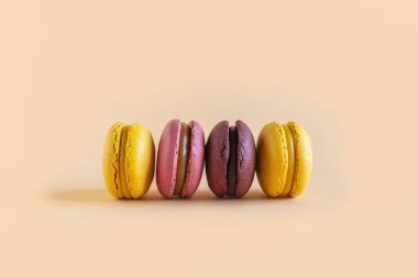 Sarı pastel arka planda lezzetli Fransız badem kurabiyeleri. Metin için yer.