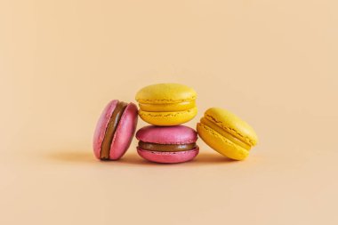 Sarı pastel arka planda lezzetli Fransız badem kurabiyeleri. Metin için yer.