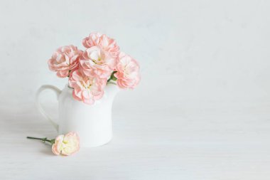 Beyaz arka planda kavanozdaki pembe karanfil çiçeklerinin romantik buketi. Metin için yer.