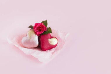 Pembe pastel arka planda gül çiçekli kalp şeklinde badem kurabiyeleri. Sevgililer Günü için konsept. Metin için yer.