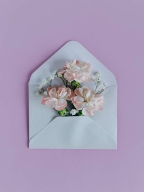 Mor pastel arka planda karanfil çiçekleri olan yumuşak bahar buketi. Metin için yer.