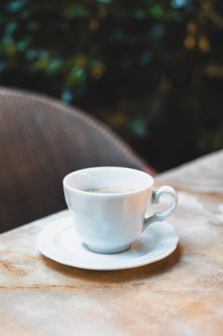 Sokak kafesindeki bir masada bir fincan kahve. Seçici odaklanma. Metin için yer.