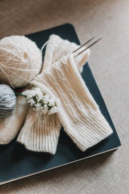 Elle örülmüş çoraplar, iğneler ve iplik yumağı. El yapımı ve yavaş yaşam için higge kavramı.