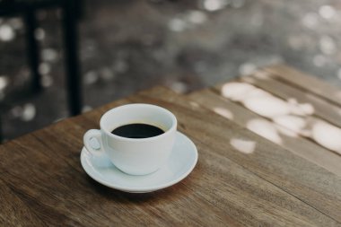 Sokak kafesindeki bir masada bir fincan sade kahve. Seçici odaklanma. Metin için yer.