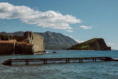 Budva 'nın muhteşem manzarası, Aziz Nicholas adası ve Budva yakınlarındaki deniz. Güzel bulutlu gökyüzü. Karadağ 'da seyahat hedefi.