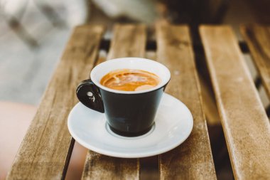 Sokak kafesindeki bir masada bir fincan sade kahve. Seçici odaklanma. Metin için yer.