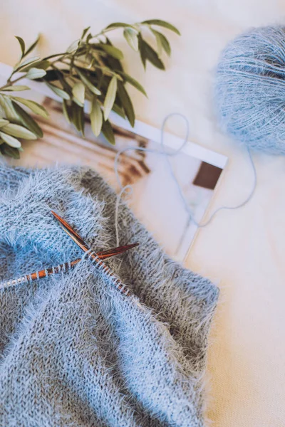 İğneli el örgüsü ve beyaz arka planda gri mavi iplik topu. El yapımı ve yavaş yaşam için higge kavramı.