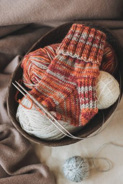 Elle örülmüş çoraplar, iğneler ve iplik yumağı. El yapımı ve yavaş yaşam için higge kavramı.