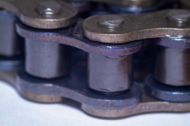 Makro, siyah-altın renkli motosiklet zincirlerini yakından çeker.