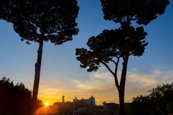 Roma Forumu 'nun ufukta batan güneşi, Roma şehrinin merkezinde bulunan çok sayıda antik hükümet binasının kalıntılarıyla çevrili popüler bir turistik cazibe merkezi haline getirmiştir..  