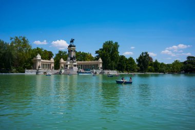 Madrid, İspanya, 20 Haziran 2018: Retiro Park Gölü, El Parque del Buen Retiro 'nun göbeğinde kayıklardan hoşlanan ziyaretçiler için popüler bir yerdir..
