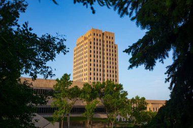 The North Dakota State Capitol, pictured here from the Capitol Grounds Native Prairie at Bismarck, is a 21-story Art Deco tower that is the tallest habitable building in the state.  