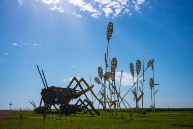 Dickinson, ND, ABD - 19 Haziran 2022: Tarladaki Grasshoppers 32 millik Büyülü Otoyol boyunca inşa edilen 8 hurda metal heykelden biridir. Koleksiyon dünyanın en büyük koleksiyonu olarak kabul edilir. Projeyi ressam Gary Greff tasarladı.