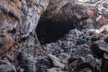 Arco, ID, USA - Jun 27, 2022: Tourists explore caves that were formed in the lava fields at Craters of the Moon National Monument & Preserve during a summer day. 