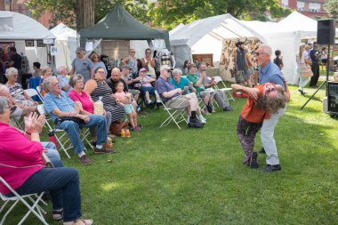 Norwich, NY, ABD - 10 Eylül 2022: Yaşlı bir çift, yerel sanatçıların ücretsiz olarak katıldığı Rengo Chenango Sanat Festivali 'nde canlı Dixieland müziği eşliğinde dans ediyor.. 