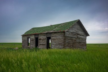 Boş bir çiftlik evi, bulutlu bir günde Kuzey Dakota 'nın çayırlarında dinlenir.. 