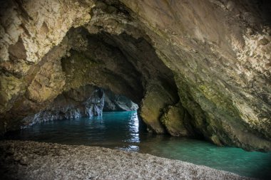 Kefalonia adasındaki Myrtos Sahili 'ndeki mağarada kayalıklar ve su