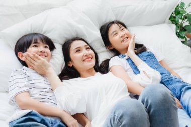 Mutlu Asyalı aile gülümseyen anne, oğul ve kız yatak odasında. Anne, oğul ve kız evde iyi vakit geçirin. Anne ve çocuklar arasındaki aşk ilişkisi ya da bağ. Halk yaşam tarzı konsepti