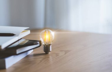 Parlak lamba. Bilgi edinme ya da eğitim yoluyla iş başarısı bilgisi. Dizüstü bilgisayarla çalışmak, okumak ya da ders çalışmak. Evde çevrimiçi kurs ya da e-öğrenim dersi alınıyor