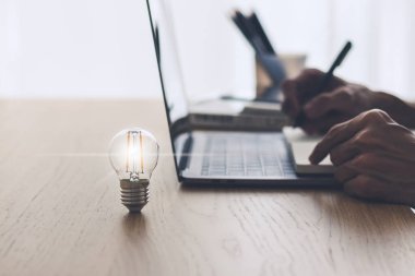 Parlak ışık ya da dizüstü bilgisayarlı parlak lamba. Ticari başarı fikri ve eğitim, öğrenim ve öğrenim kavramı. İş adamı ya da öğrenci bilgisi ilham ve bilişsel gelişim