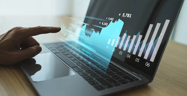 Yatırım grafiği için dizüstü bilgisayar kullanan bir iş adamı. Döviz piyasasını online olarak planlayan ve ticaretini yapan profesyonel tüccar veya işadamı
