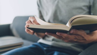 İşadamı kitap üzerinde çalışıyor ve okuyor. Öğrenci evde ders kitabı okuyup öğreniyor. Eğitim bilgi geliştirme ve bilişsel öğrenme konusunda başarı fikri