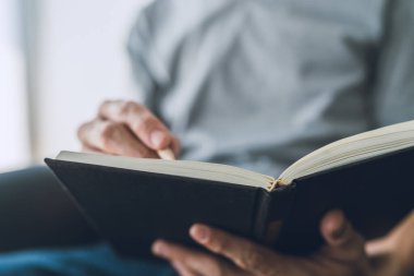 İşadamı kitap üzerinde çalışıyor ve okuyor. Öğrenci evde ders kitabı okuyup öğreniyor. Eğitim bilgi geliştirme ve bilişsel öğrenme konusunda başarı fikri