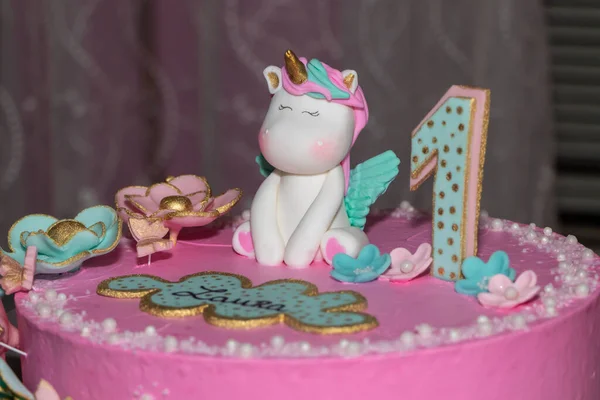 Pink cake. Unicorn cake with pink frosting and number one decoration.