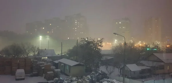 ランタンの灯りに照らされた冬の夜の街で初めての雪 — ストック写真