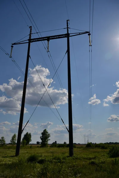 雲に覆われた青い夏の空に対して高電圧の電柱と送電線 — ストック写真