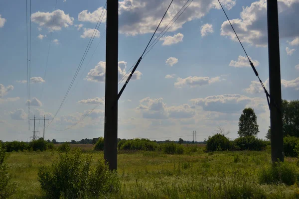 青い夏の空に対する高電圧の電柱と送電線 — ストック写真