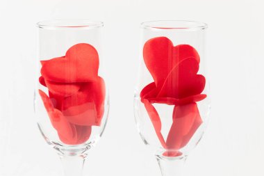 Beyaz ahşap bir masada kırmızı kalpli iki şampanya bardağı. Yakın plan. seçici odak