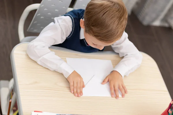 Söt Förstaklassare Skoluniform Hemma Medan Han Sitter Isolerad Vid Skrivbordet — Stockfoto